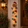 Cheerful gingerbread man Christmas door hanger with cookies, bows and stars